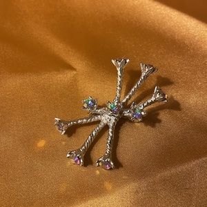 Vintage silver pin with irredentist colored rhinestones. Rope design